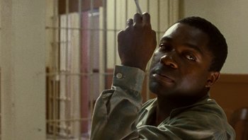 Movie still from “The Paperboy” (2012), directed by Lee Daniels – A man holding a cigarette in his hand; Close Up shot, Low angle