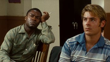 Movie still from “The Paperboy” (2012), directed by Lee Daniels – Two men sitting at a table with a cigarette in their mouth; Close Up shot, Over the shoulder angle