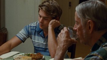 Movie still from “The Paperboy” (2012), directed by Lee Daniels – A man and an old man sitting at a dinner table drinking water; Medium shot, Over the shoulder angle