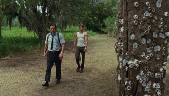 Movie still from “The Paperboy” (2012), directed by Lee Daniels – A man and a woman walking on a dirt path; Wide shot, Low angle