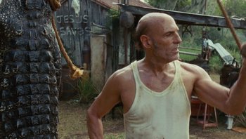 Movie still from “The Paperboy” (2012), directed by Lee Daniels – A man in a tank top standing next to a pole; Medium shot, Low angle