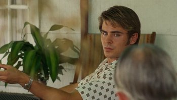 Movie still from “The Paperboy” (2012), directed by Lee Daniels – A man in a white shirt is looking at a green plant; Close Up shot, Over the shoulder angle