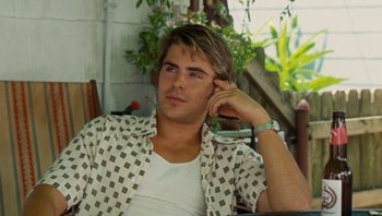 Movie still from “The Paperboy” (2012), directed by Lee Daniels – A man sitting on a chair talking on a cell phone; Medium shot, Over the shoulder angle