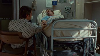 Movie still from “The Paperboy” (2012), directed by Lee Daniels – A man in a hospital bed and a woman in a room; Medium shot, High angle