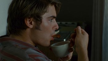Movie still from “The Paperboy” (2012), directed by Lee Daniels – A young man is eating something while holding a cup; Close Up shot, Over the shoulder angle