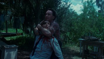 Movie still from “The Paperboy” (2012), directed by Lee Daniels – A man holding another man with blood all over his face; Medium shot, Low angle