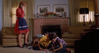 Movie still from “Duel” (1971), directed by Steven Spielberg – A woman and two children sitting on the floor in front of a fire place; Wide shot, High angle