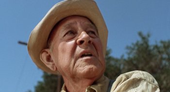 Movie still from “Duel” (1971), directed by Steven Spielberg – An older man wearing a hat looking up at the sky; Close Up shot, Low angle