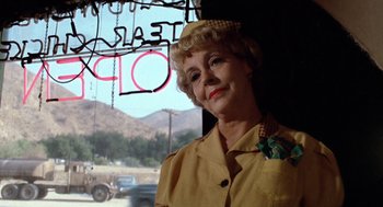 Movie still from “Duel” (1971), directed by Steven Spielberg – An older woman standing in front of a window; Close Up shot, Over the shoulder angle