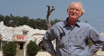 Movie still from “Duel” (1971), directed by Steven Spielberg – An older man standing in front of a building; Medium shot, Low angle