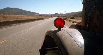 Movie still from “Duel” (1971), directed by Steven Spielberg – A red traffic light on the side of the road; Wide shot, Low angle
