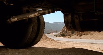 Movie still from “Duel” (1971), directed by Steven Spielberg – A view of a dirt road from underneath a vehicle; Extreme Wide shot, Low angle