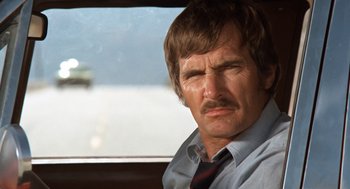 Movie still from “Duel” (1971), directed by Steven Spielberg – A person wearing a shirt and a tie; Close Up shot, Low angle