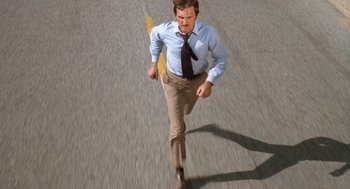 Movie still from “Duel” (1971), directed by Steven Spielberg – A man in a tie is running down the street; Wide shot, High angle