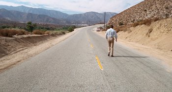 Movie still from “Duel” (1971), directed by Steven Spielberg – A man walking down the middle of a road; Extreme Wide shot, High angle