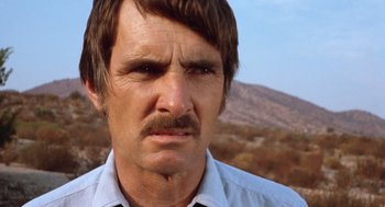 Movie still from “Duel” (1971), directed by Steven Spielberg – A person with a mustache; Close Up shot, Over the shoulder angle