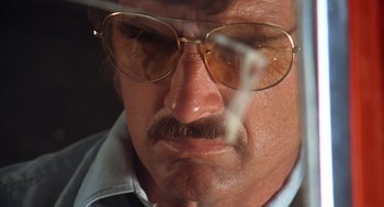 Movie still from “Duel” (1971), directed by Steven Spielberg – A person wearing glasses and smoking a cigarette; Extreme Close Up shot, Low angle