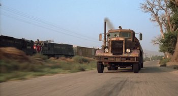 Movie still from “Duel” (1971), directed by Steven Spielberg – An old truck is driving down the road; Wide shot, Low angle