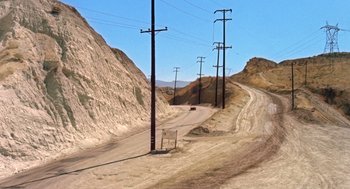 Movie still from “Duel” (1971), directed by Steven Spielberg – A dirt road that has power lines on it; Extreme Wide shot, High angle
