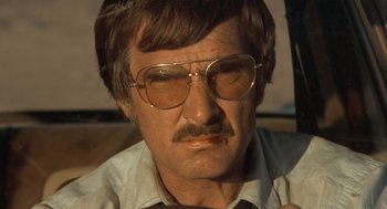 Movie still from “Duel” (1971), directed by Steven Spielberg – An older man wearing glasses and a mustache; Close Up shot, Low angle
