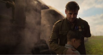 Movie still from “Dumbo” (2019), directed by Tim Burton – A man in a uniform holding a boy in his arms; Medium shot, Over the shoulder angle