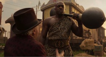 Movie still from “Dumbo” (2019), directed by Tim Burton – A man holding a baseball bat over another man's head; Medium shot, Low angle