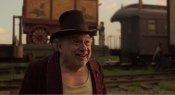 Movie still from “Dumbo” (2019), directed by Tim Burton – An older man wearing a brown hat and a red jacket; Close Up shot, Low angle