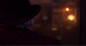 Movie still from “Dumbo” (2019), directed by Tim Burton – An older man wearing a hat and a red jacket; Close Up shot, Over the shoulder angle