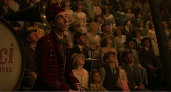 Movie still from “Dumbo” (2019), directed by Tim Burton – A crowd of people sitting and standing in a room; Medium shot, High angle