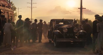 Movie still from “Dumbo” (2019), directed by Tim Burton – A group of people standing around a car; Extreme Wide shot, Low angle