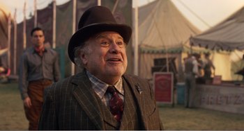 Movie still from “Dumbo” (2019), directed by Tim Burton – An older man wearing a suit and a hat; Medium shot, Over the shoulder angle