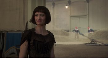 Movie still from “Dumbo” (2019), directed by Tim Burton – A woman standing in front of a wall with a baseball bat; Medium shot, Over the shoulder angle