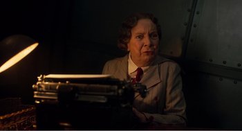 Movie still from “Dumbo” (2019), directed by Tim Burton – An older woman sitting in front of an old fashioned typewriter; Close Up shot, Low angle