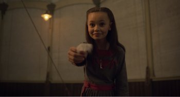 Movie still from “Dumbo” (2019), directed by Tim Burton – A young girl holding a piece of paper in her hand; Medium shot, Over the shoulder angle