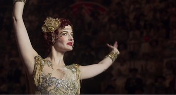 Movie still from “Dumbo” (2019), directed by Tim Burton – A woman with red hair wearing a gold dress; Close Up shot, Low angle