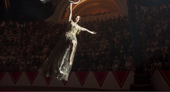 Movie still from “Dumbo” (2019), directed by Tim Burton – A woman in a white dress jumping in the air in front of an audience; Wide shot, Low angle