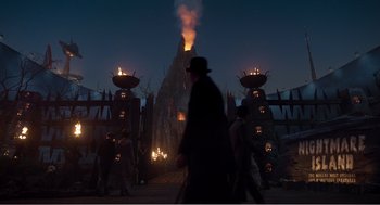Movie still from “Dumbo” (2019), directed by Tim Burton – A group of people standing around a building with fire; Extreme Wide shot, High angle