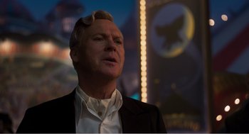 Movie still from “Dumbo” (2019), directed by Tim Burton – A person wearing a suit and tie; Close Up shot, Low angle
