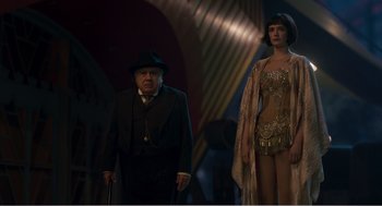 Movie still from “Dumbo” (2019), directed by Tim Burton – An older man and a young woman standing next to each other; Medium shot, Low angle