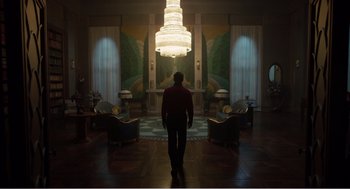 Movie still from “Dumbo” (2019), directed by Tim Burton – A man standing in the middle of a living room; Extreme Wide shot, Low angle