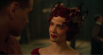 Movie still from “Dumbo” (2019), directed by Tim Burton – A woman with red curly hair and red lipstick; Close Up shot, Over the shoulder angle