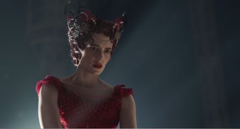 Movie still from “Dumbo” (2019), directed by Tim Burton – A woman in a red dress and a red flower crown; Close Up shot, Low angle