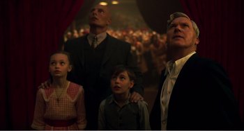 Movie still from “Dumbo” (2019), directed by Tim Burton – A group of people standing in front of an audience; Medium shot, Low angle