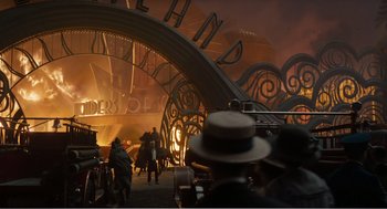 Movie still from “Dumbo” (2019), directed by Tim Burton – A group of people standing around in front of a building; Extreme Wide shot, High angle