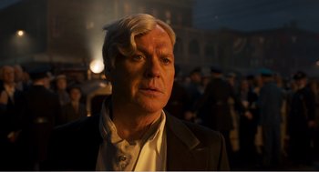 Movie still from “Dumbo” (2019), directed by Tim Burton – A person wearing a suit and tie; Close Up shot, Over the shoulder angle