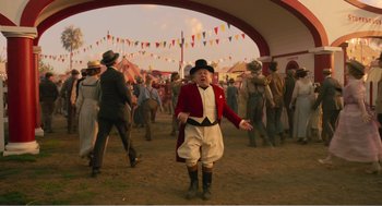 Movie still from “Dumbo” (2019), directed by Tim Burton – An old man in a red jacket and a hat; Wide shot, Low angle