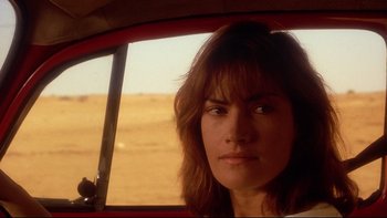 Movie still from “Dust Devil” (1992), directed by Richard Stanley – A person sitting in a car; Close Up shot, Over the shoulder angle