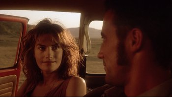 Movie still from “Dust Devil” (1992), directed by Richard Stanley – A man and a woman sitting in the back of a car; Close Up shot, Over the shoulder angle