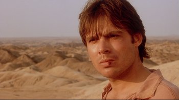 Movie still from “Dust Devil” (1992), directed by Richard Stanley – A person in a desert area; Close Up shot, Low angle