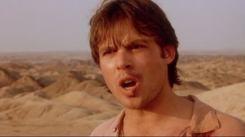 Movie still from “Dust Devil” (1992), directed by Richard Stanley – A person in a desert setting; Close Up shot, Low angle